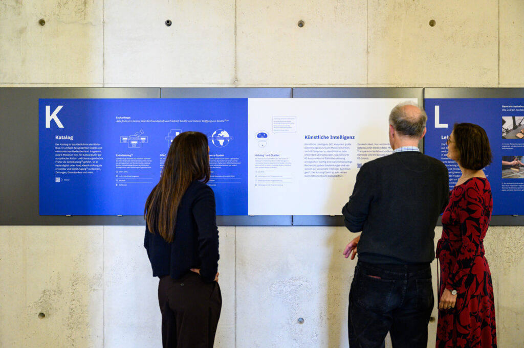 Besuchende stehen vor einer Ausstellungstafel